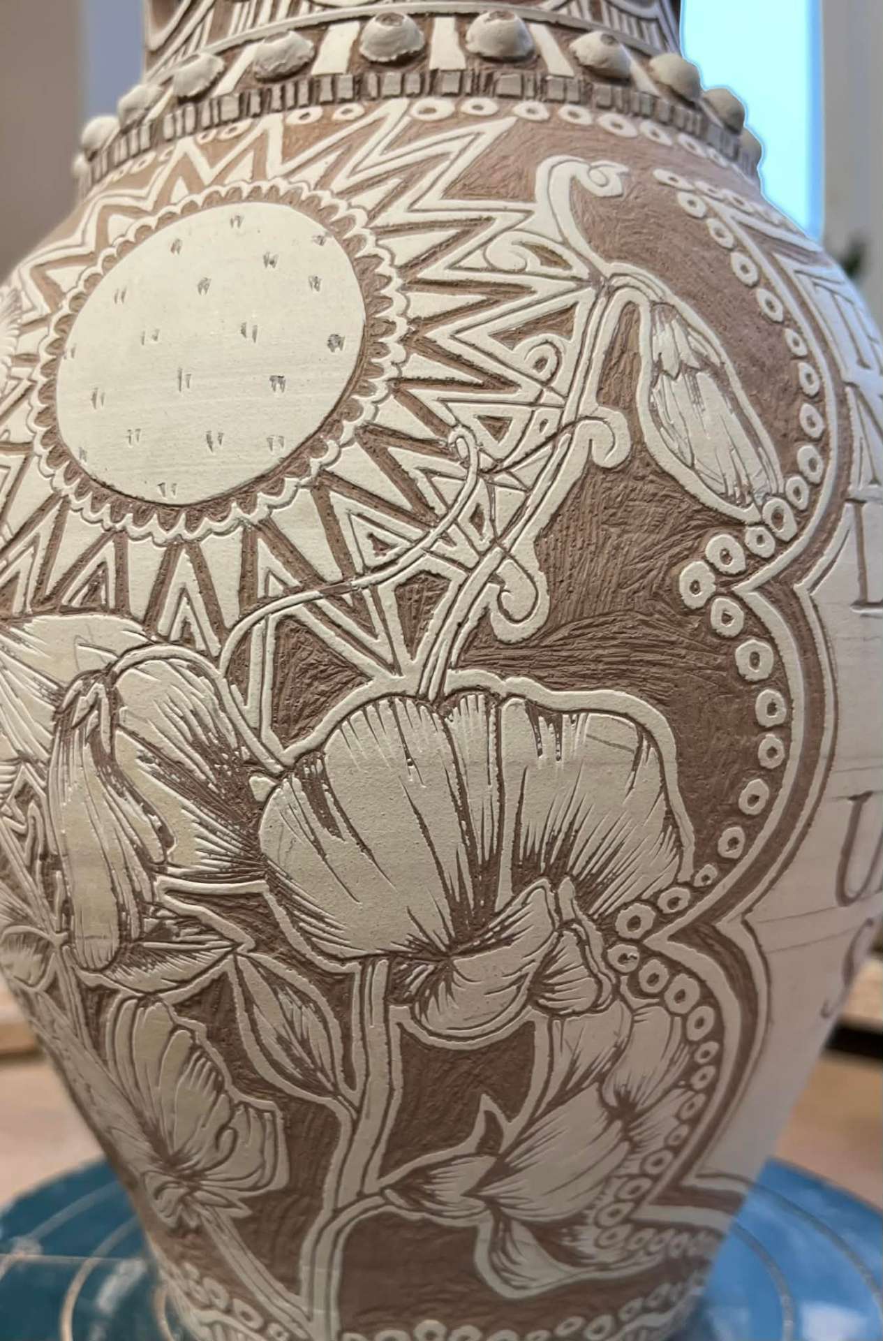 Poppy design carved through white slip before firing.